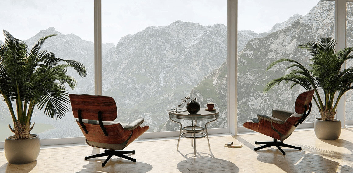 Pièce avec 2 fauteuils confortables et une table basse, une grande baie vitrée donnant sur les montagnes